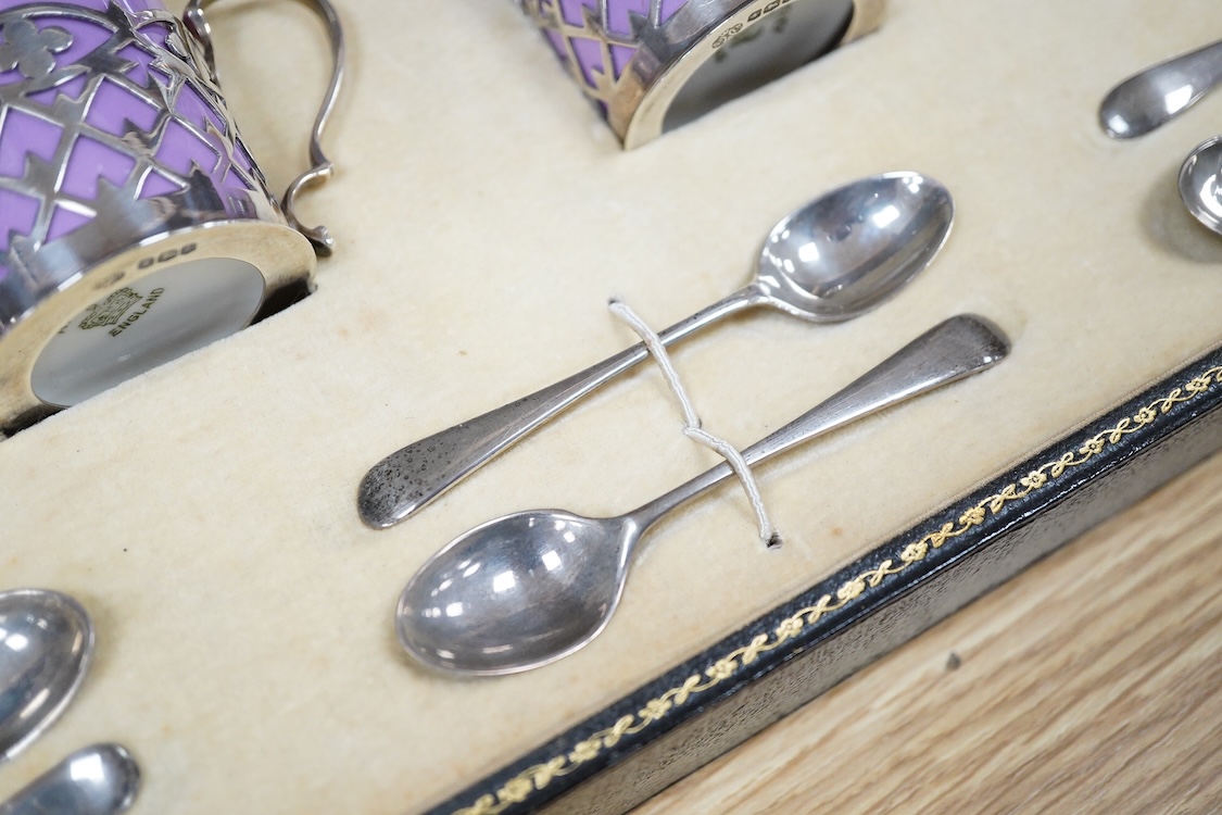 A cased Aynsley coffee set with silver mounted coffee cans and silver teaspoons, William Hutton & Sons, Sheffield, 1924, the leather case 38cm wide